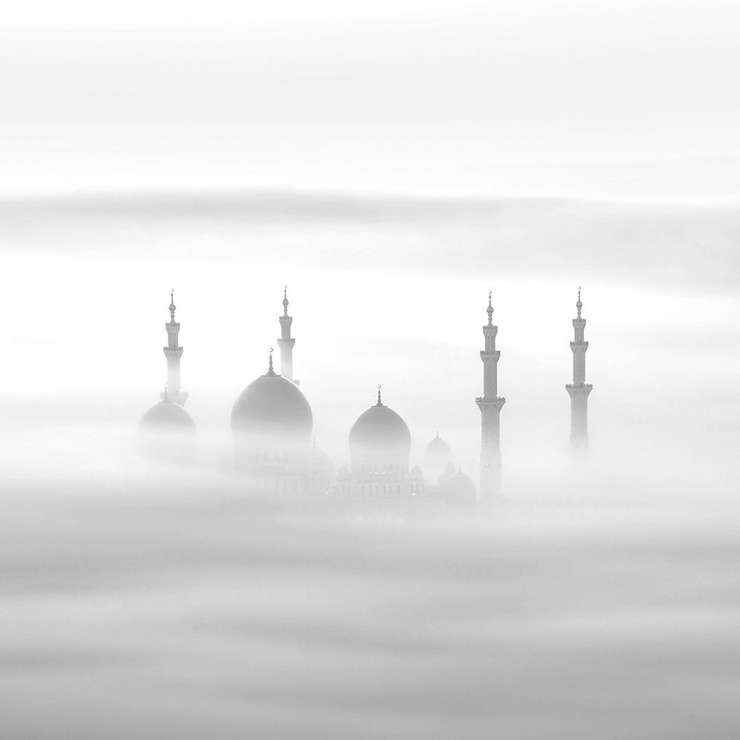 A breathtaking photograph of the Sheikh Zayed Mosque In Abu Dhabi At Sunrise Through A Fog By Khalid Al Hammadi used as a black & white featured image for this DCT portfolio item in black & white.